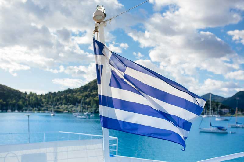 A Greek flag on the background of a sunny day